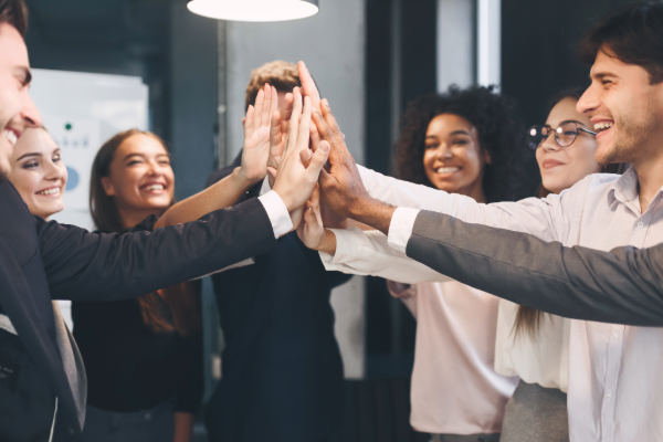 an Australian business team give a high five together to show their collaborative understanding after doing the effective communication course.